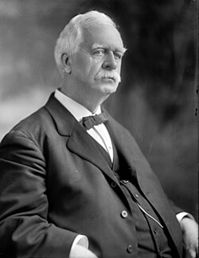 Black and white historical portrait of Sereno Elisha Payne, a founder of the Cayuga County Bar Association, wearing a formal suit and bow tie